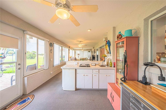 kitchen featuring white cabinetry, ceiling fan, dark colored carpet, white refrigerator, and kitchen peninsula