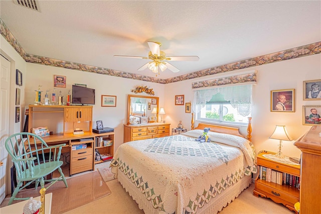 carpeted bedroom featuring a textured ceiling and ceiling fan