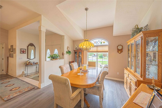 dining space with vaulted ceiling, a chandelier, dark wood-type flooring, and a textured ceiling