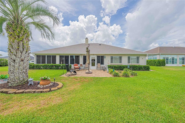 back of property with a yard and a patio area