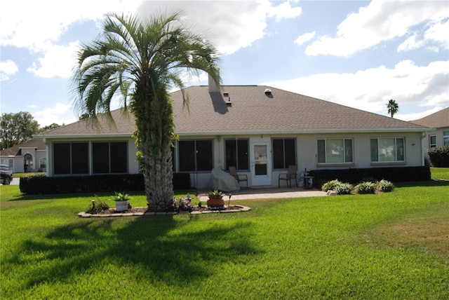 back of property with a lawn and a patio