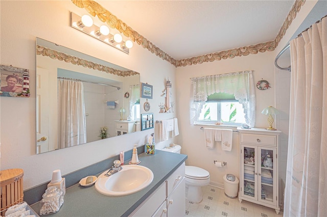 bathroom with a shower with shower curtain, vanity, and toilet