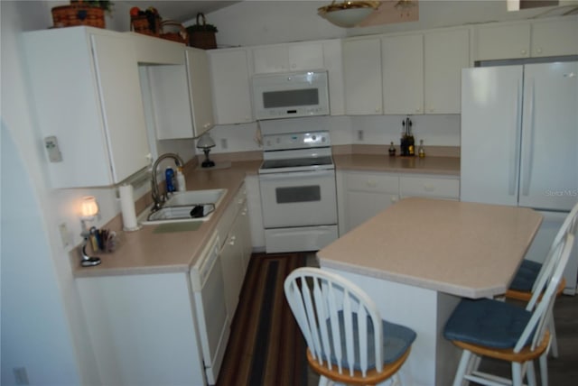 5495 NW 23rd Pl, Ocala, FL 34482 - kitchen featuring a sink, white appliances, a breakfast bar, white cabinetry, and light countertops