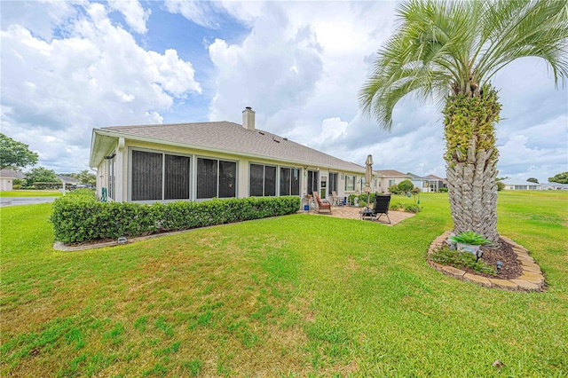 5495 NW 23rd Pl, Ocala, FL 34482 - back of house featuring a patio area, a chimney, and a lawn