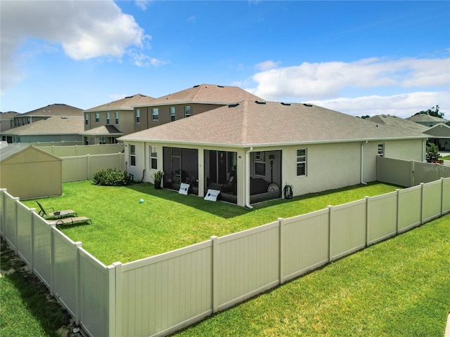 back of house with a sunroom and a yard