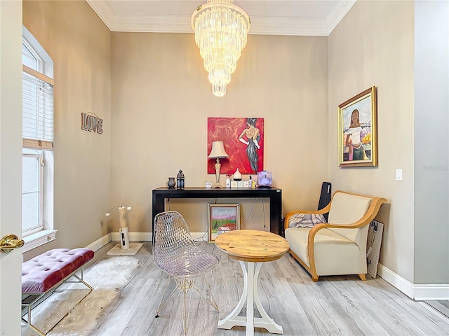 sitting room featuring a wealth of natural light, crown molding, hardwood / wood-style flooring, and an inviting chandelier