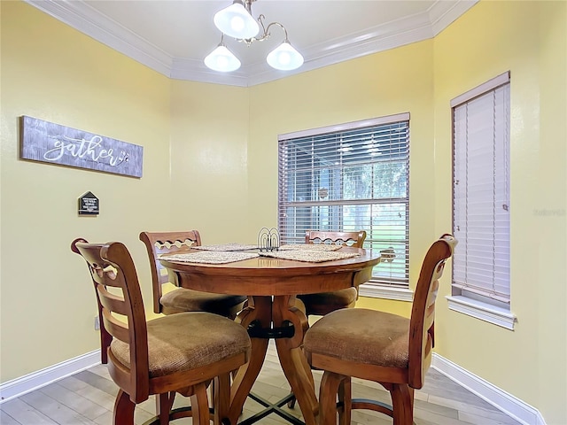 dining space with crown molding, a notable chandelier, and hardwood / wood-style flooring