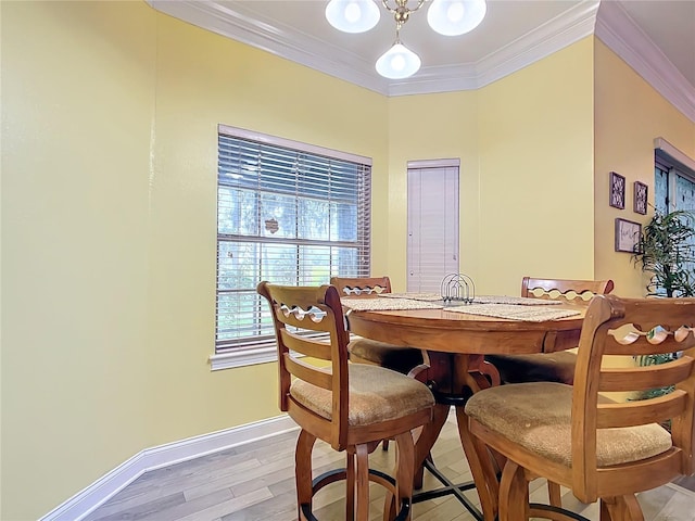 dining space featuring crown molding and light hardwood / wood-style flooring