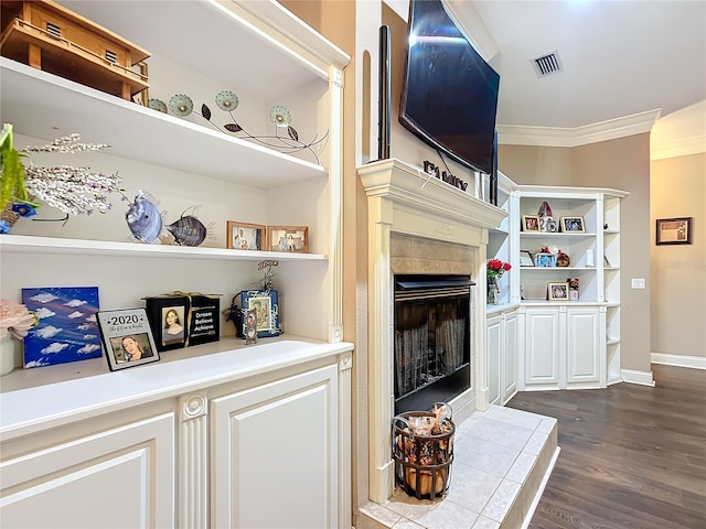 living room with dark hardwood / wood-style flooring, ornamental molding, and a fireplace