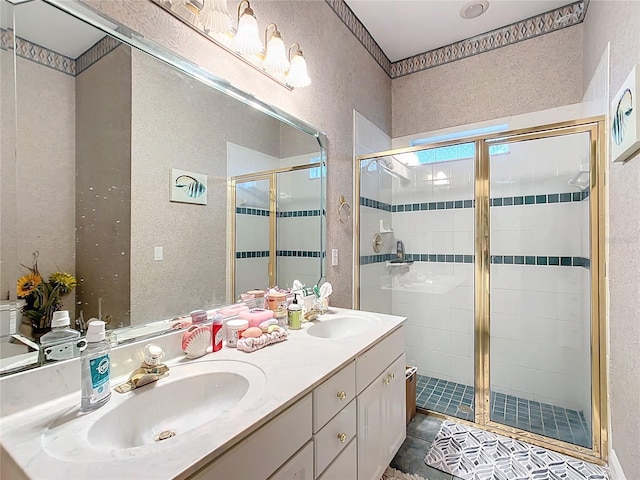 bathroom featuring a shower with door and vanity