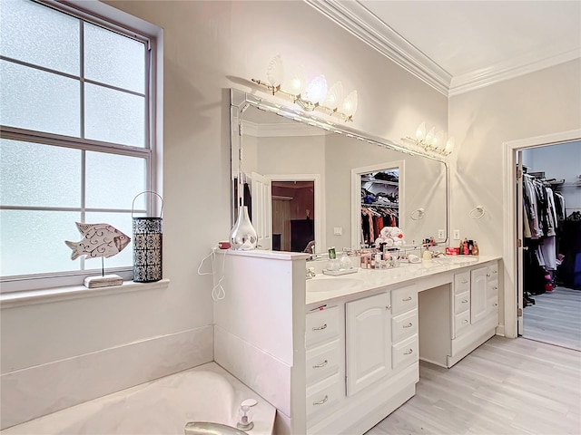 bathroom featuring vanity, a tub, plenty of natural light, and ornamental molding