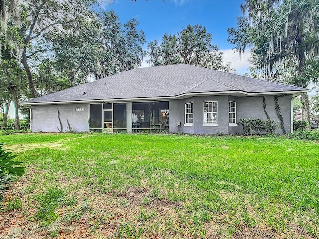 rear view of property with a sunroom and a yard