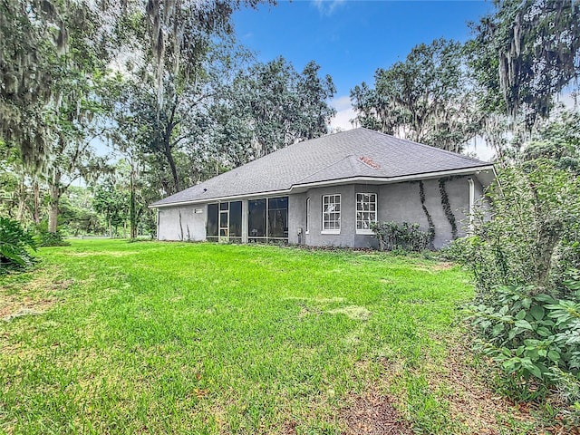 back of property featuring a lawn and a sunroom