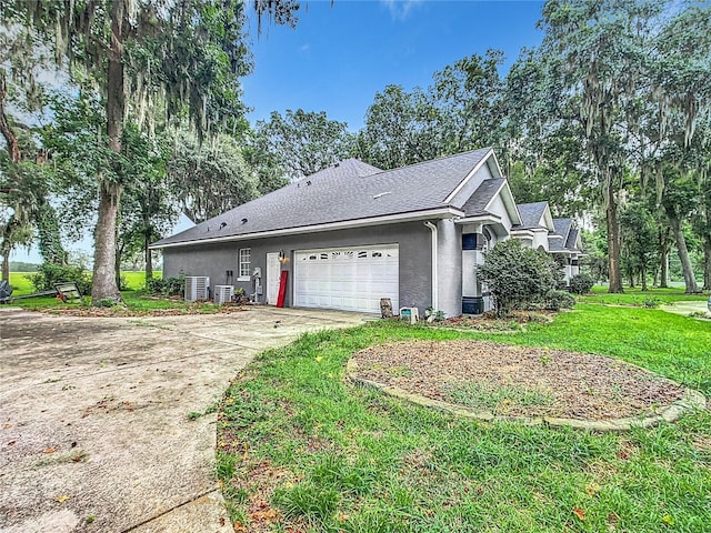 view of side of home featuring cooling unit, a garage, and a yard