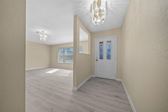 entryway with light wood-type flooring and a notable chandelier