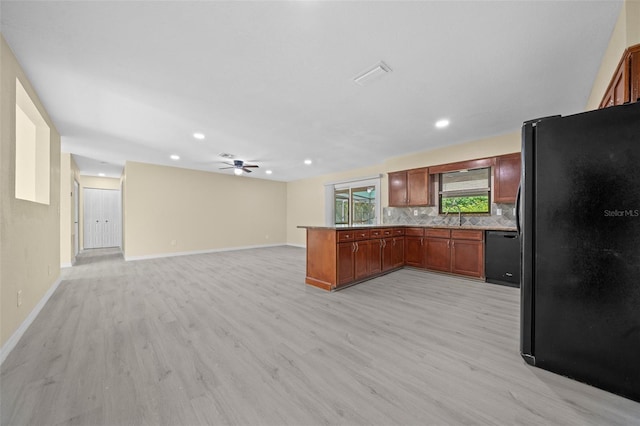 kitchen with black appliances, decorative backsplash, ceiling fan, light hardwood / wood-style floors, and kitchen peninsula