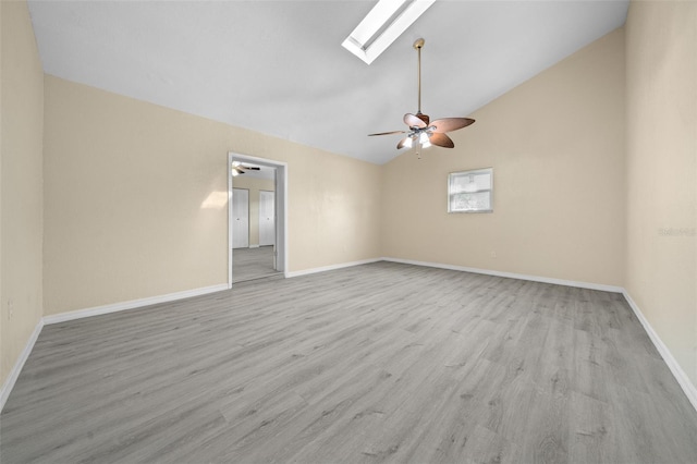 spare room with lofted ceiling with skylight, light hardwood / wood-style flooring, and ceiling fan