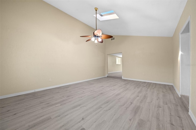 unfurnished room featuring ceiling fan, vaulted ceiling with skylight, and light wood-type flooring