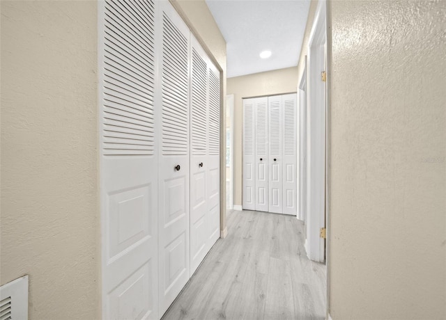 corridor with light hardwood / wood-style floors