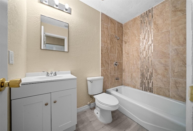 full bathroom featuring vanity, a textured ceiling, hardwood / wood-style flooring, toilet, and tiled shower / bath