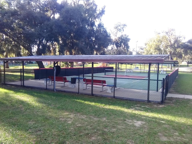 view of vehicle parking featuring a lawn and tennis court