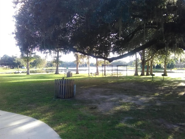 surrounding community featuring a lawn and a water view