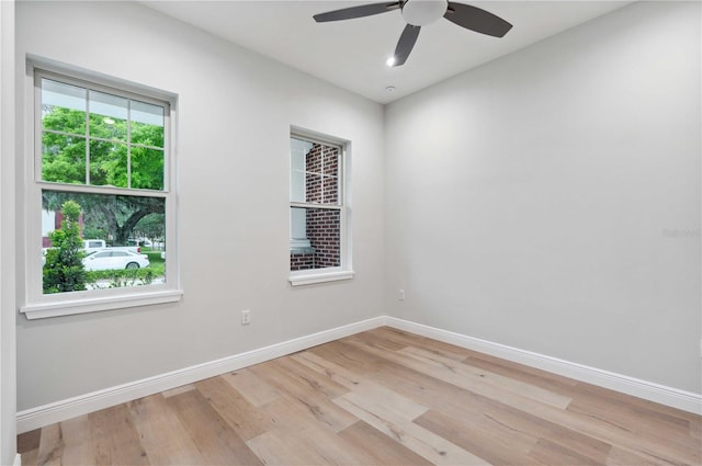 empty room with ceiling fan and light hardwood / wood-style floors