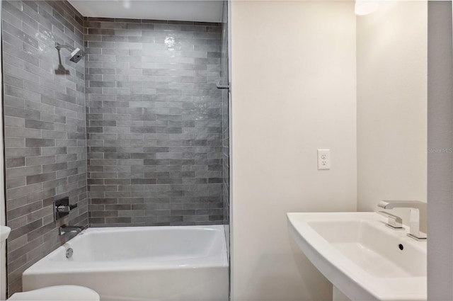 full bathroom with tiled shower / bath combo, toilet, and sink