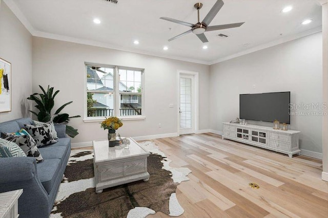 living room featuring ceiling fan, light hardwood / wood-style floors, and crown molding