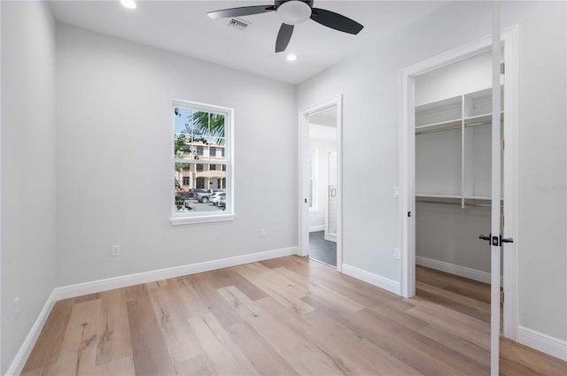 unfurnished bedroom featuring ceiling fan, a closet, and light wood-type flooring