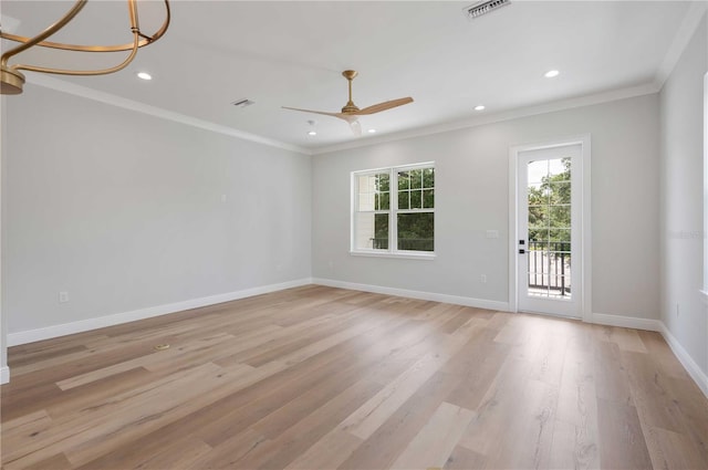 spare room featuring ceiling fan with notable chandelier, light hardwood / wood-style floors, and crown molding