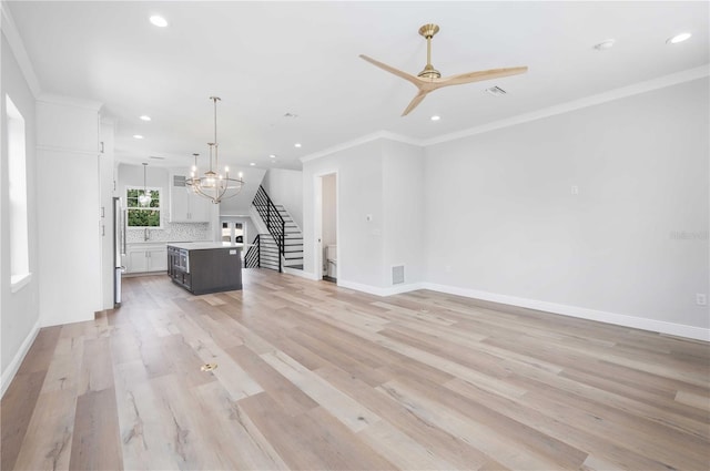 unfurnished living room with crown molding, light hardwood / wood-style flooring, and ceiling fan with notable chandelier