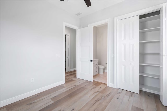 unfurnished bedroom with a closet, light hardwood / wood-style floors, ceiling fan, and ensuite bathroom