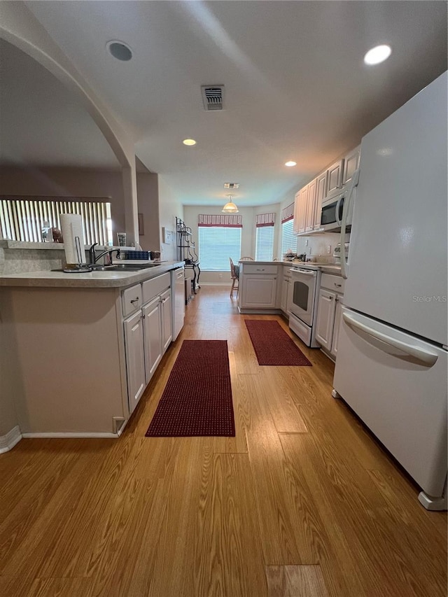 kitchen featuring sink, light hardwood / wood-style flooring, stainless steel appliances, and white cabinets