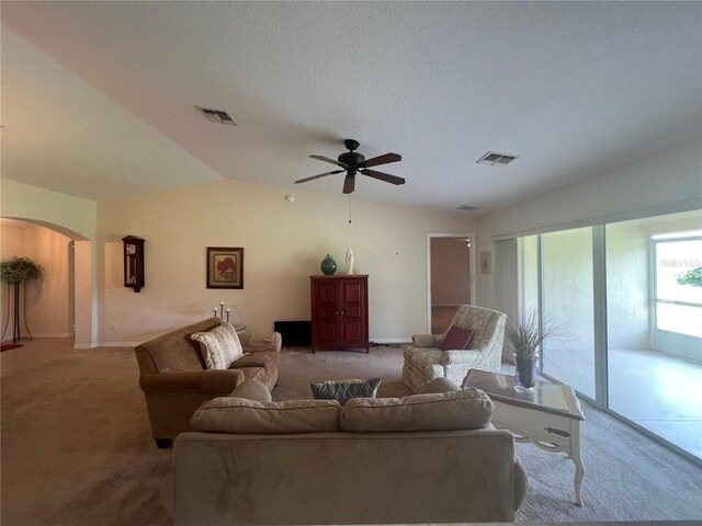 living room featuring carpet flooring, a textured ceiling, ceiling fan, and vaulted ceiling