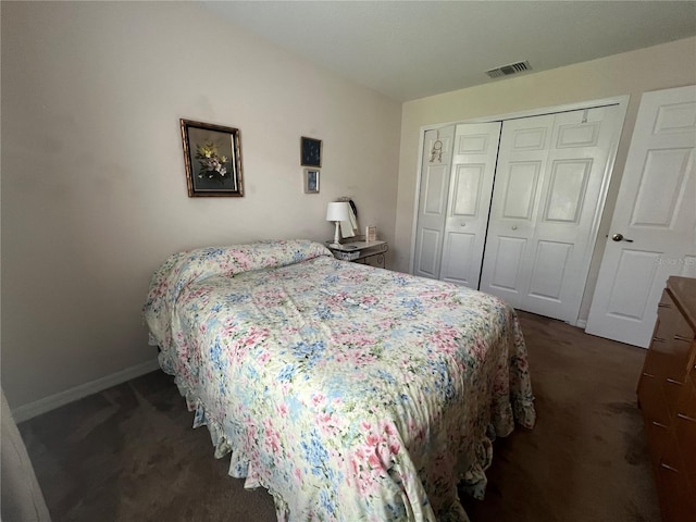 bedroom with dark carpet and a closet