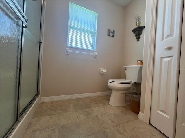 bathroom featuring toilet and a shower with shower door