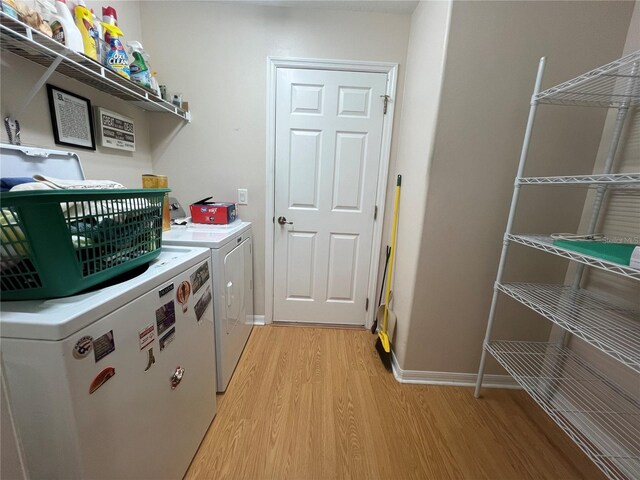 laundry room featuring washing machine and clothes dryer and light wood-type flooring