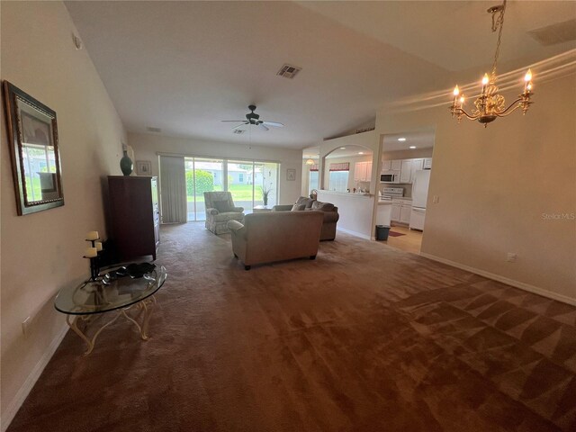 unfurnished living room featuring carpet and ceiling fan with notable chandelier