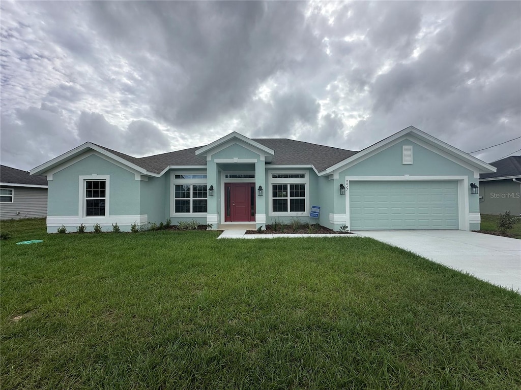 ranch-style house featuring a garage and a front lawn