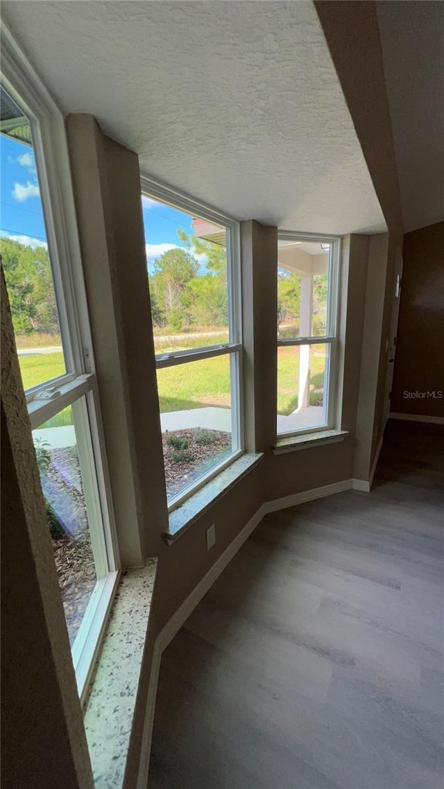 unfurnished room featuring hardwood / wood-style flooring and a textured ceiling