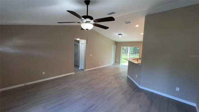 spare room featuring ceiling fan, lofted ceiling, and light hardwood / wood-style floors