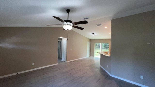 unfurnished room featuring hardwood / wood-style floors, vaulted ceiling, and ceiling fan