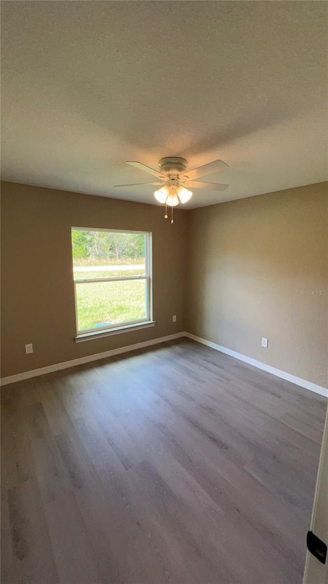 empty room with ceiling fan, hardwood / wood-style flooring, and a textured ceiling