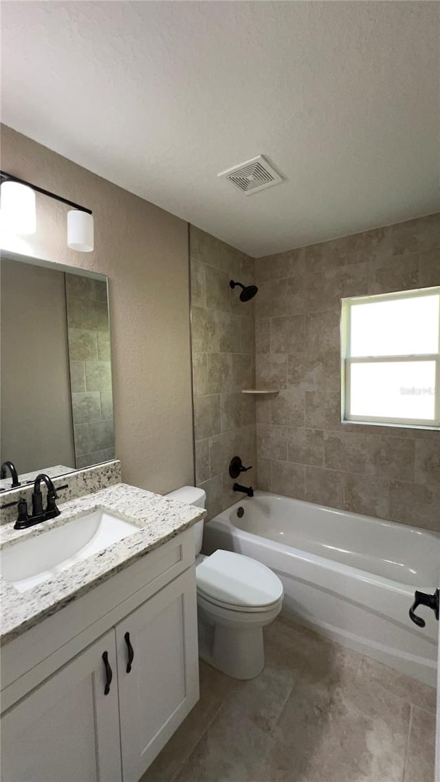 full bathroom featuring vanity, toilet, and tiled shower / bath combo