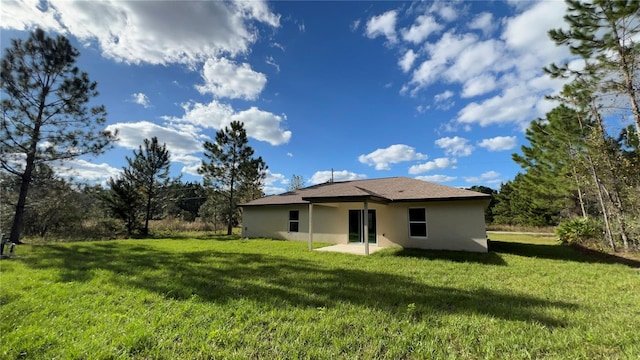 back of property with a lawn and a patio area