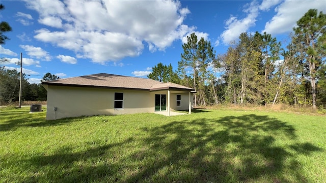 rear view of property featuring a lawn