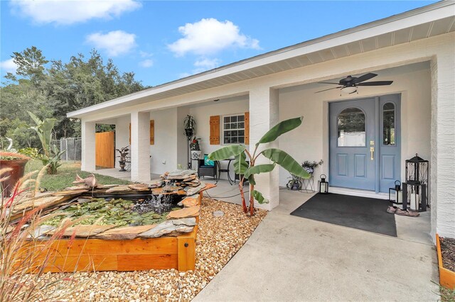 entrance to property with ceiling fan and a patio