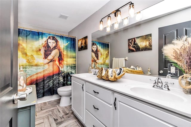 bathroom featuring parquet floors, vanity, and toilet