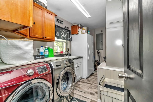 washroom with sink, washer and clothes dryer, electric panel, and cabinets